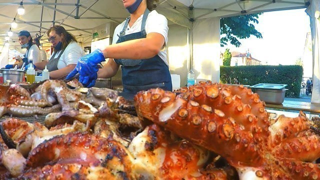 'Italy Street Food. Women Master Grill of Huge Octopuses Fast. Milan Food Festival'